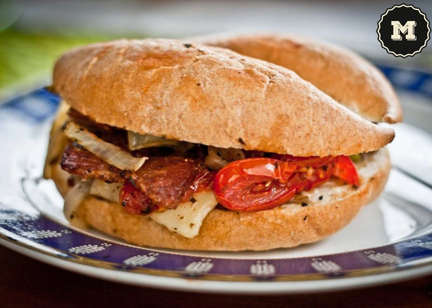 Bocadillo vegetal con queso brie, cebolla, pimiento rojo y tomates secos